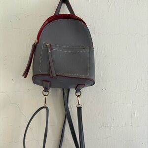 Small grey and maroon backpack with pocket in front and inside, cream interior